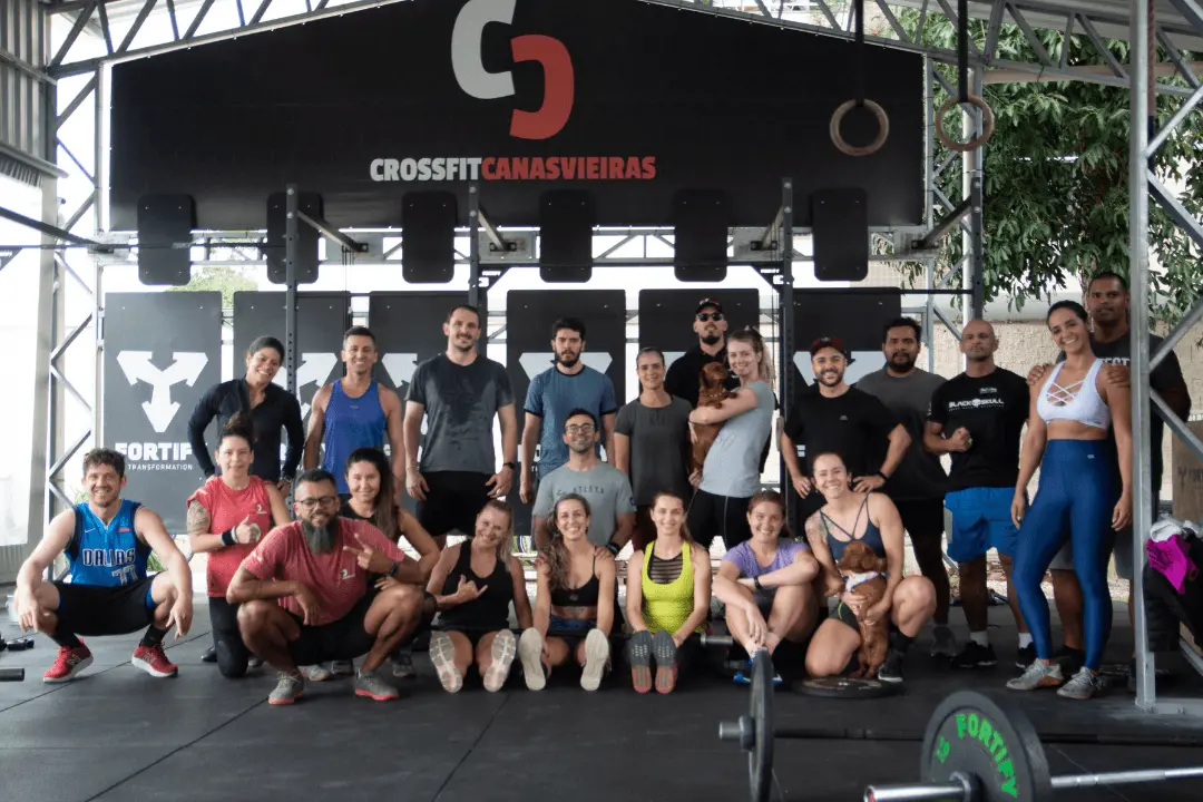 Turma do CrossFit Canasvieiras reunida no box em Canasvieiras (Florianópolis) após o treino, com coaches e alunos posando sob o banner do box.